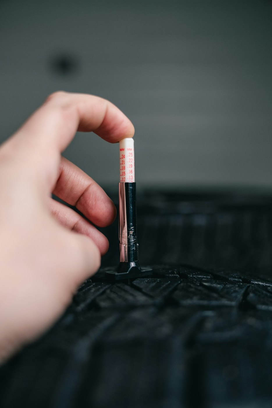 Measuring tire tread depth with a gauge